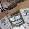 Various gardening and soil products from Build A Soil company displayed in packages, including organic amendments and fertilizers with green tree logo branding