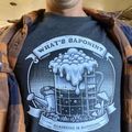 A person wearing a gray t-shirt with a gardening-themed graphic design featuring a beer mug with foam, watering can, and mushrooms, with text reading "What's Saponin? Gardening is Happening"