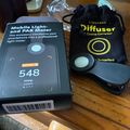 Mobile light meter device showing 548 PPFD reading next to a LightRay diffuser accessory and black carrying pouch on wooden table