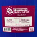 Product label for Fermented Nettle Extract showing usage instructions for soil drench, foliar spray, field application and compost booster, along with ingredients and company information on a blue container