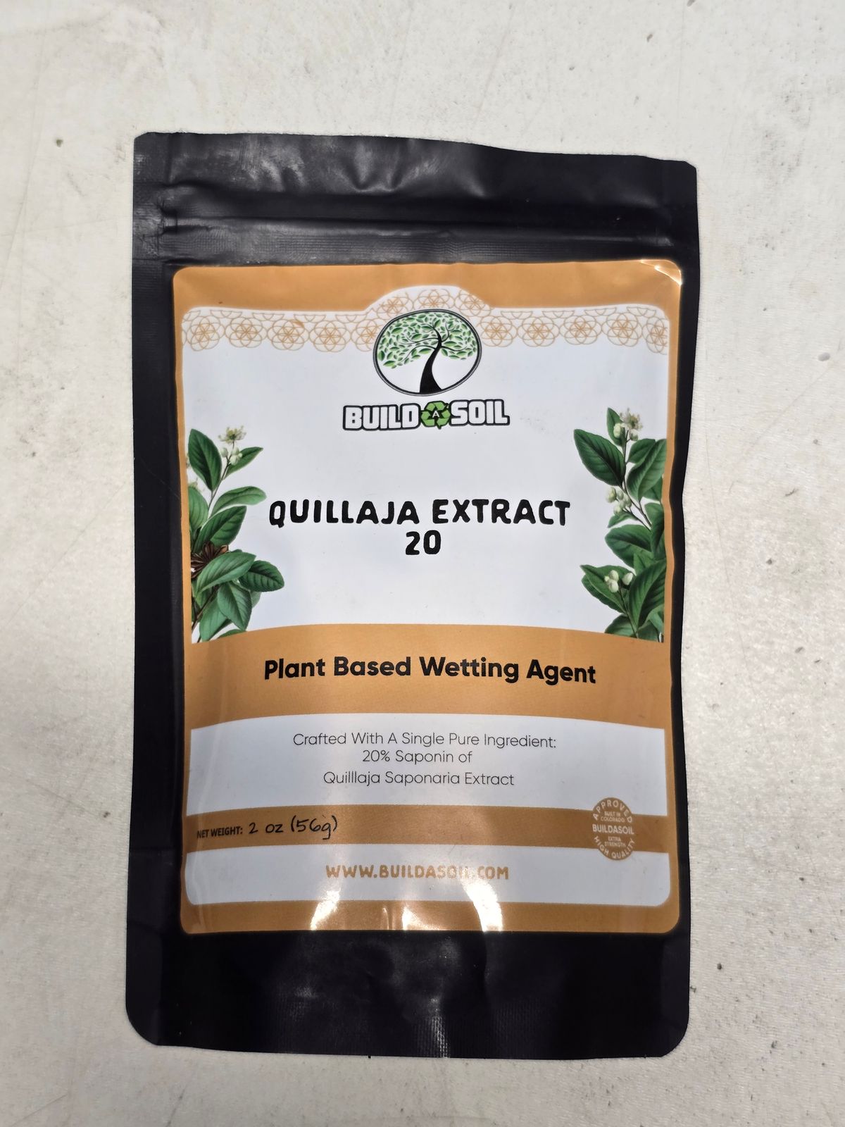 Package of BuildASoil Quillaja Extract 20 plant-based wetting agent in black resealable pouch with orange and white label featuring tree logo and plant graphics